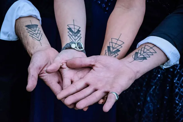 Small fine line crescent moon and Leo sign tattoos on an inner forearms
